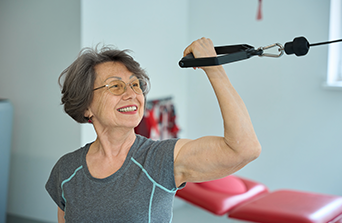 Older lady is working out inthe gym.